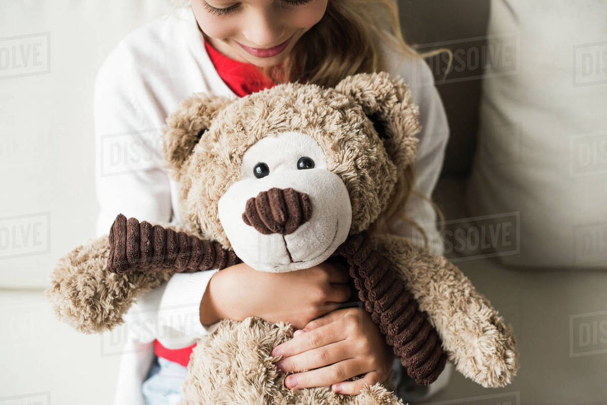 kid hugging teddy bear