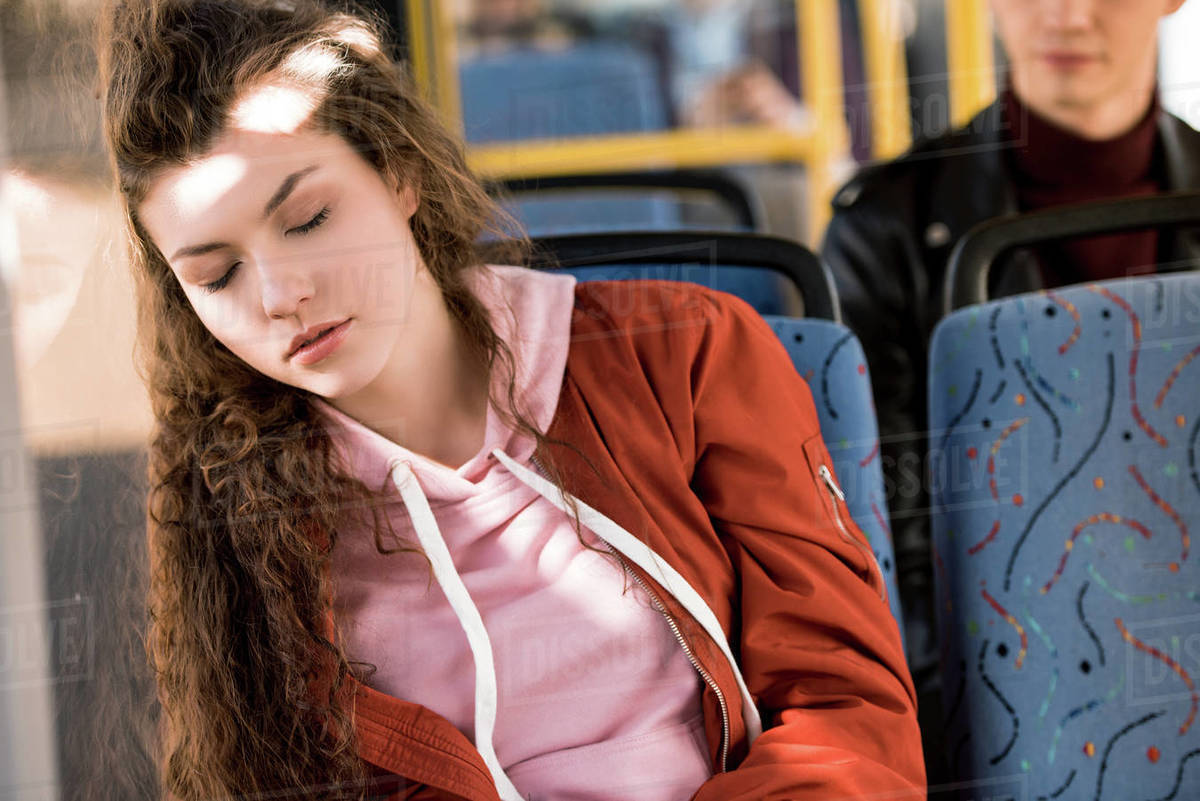 Beautiful Young Woman With Curly Hair Sleeping In Bus Stock