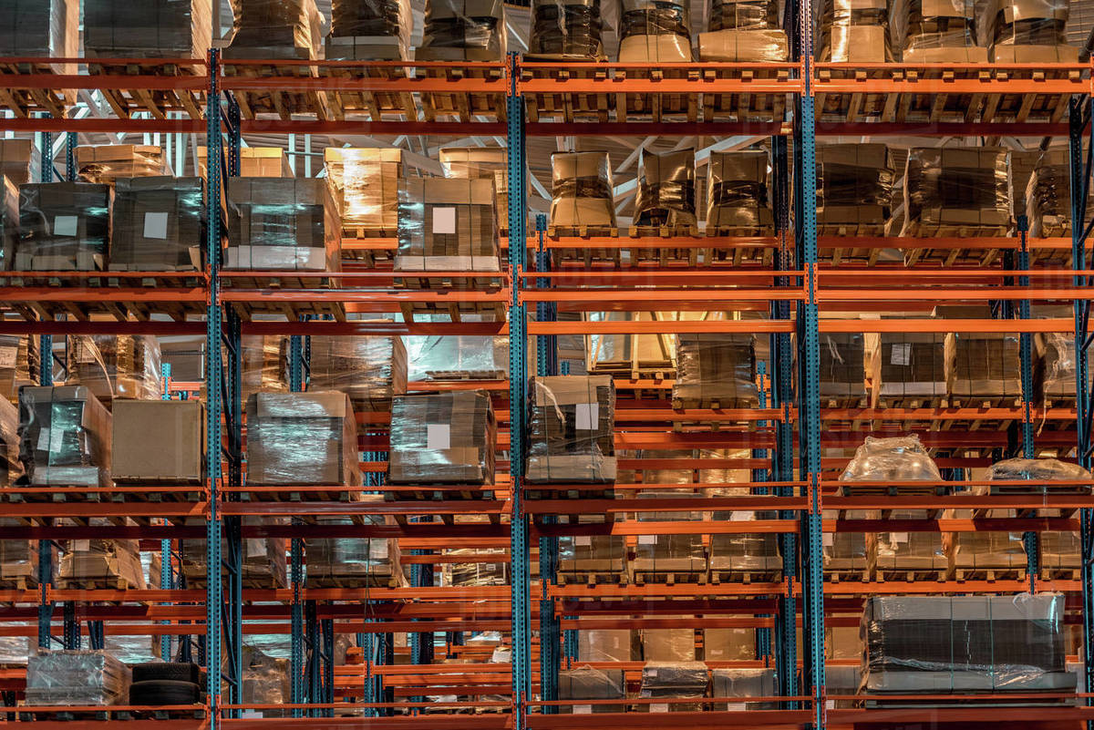 Boxes and containers on shelves in modern warehouse Stock Photo