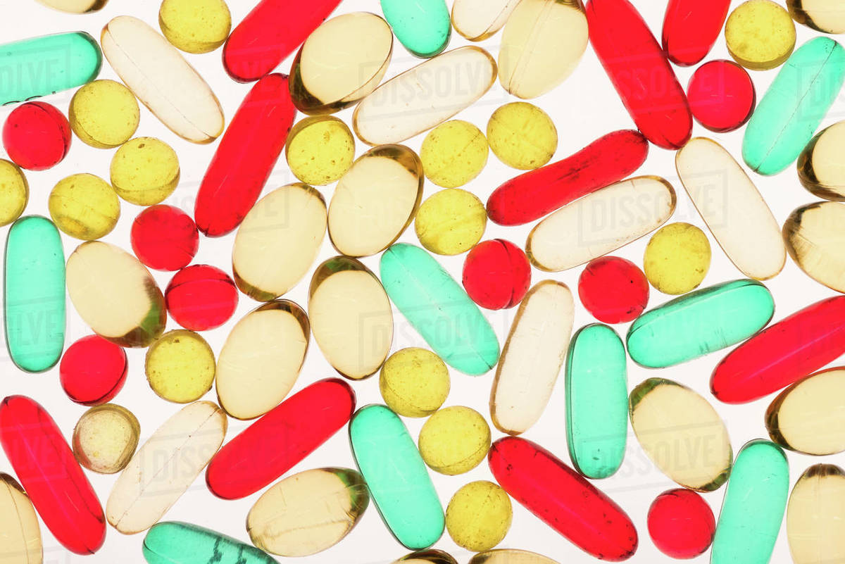 closeup view of various colorful medical capsules on white Stock