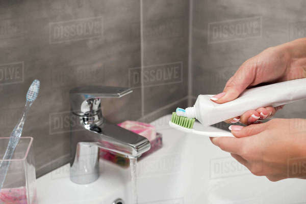 Cropped image of girl applying toothpaste on a toothbrush - Royalty ...