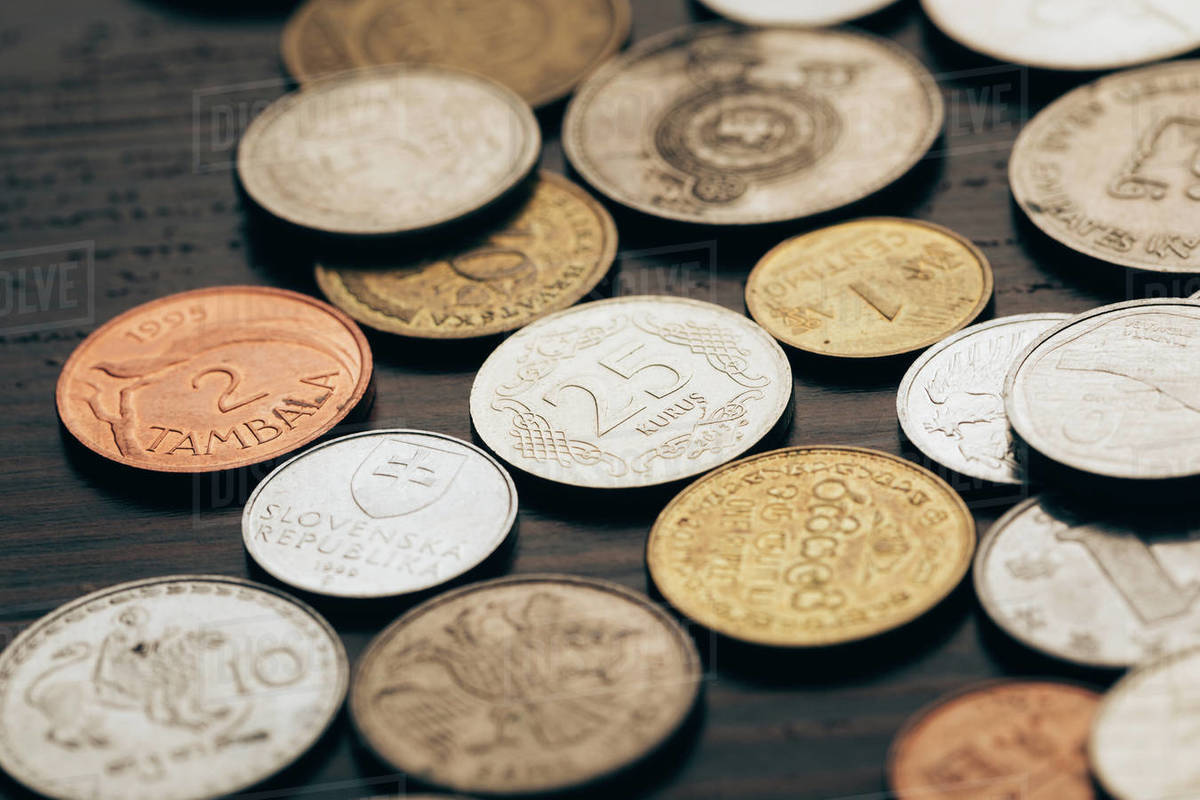Close up of collection of coins on wooden table Stock Photo Dissolve