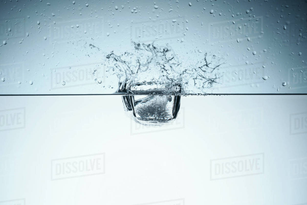 Ice cube in water with splash, isolated on white - Royalty-free Stock ...
