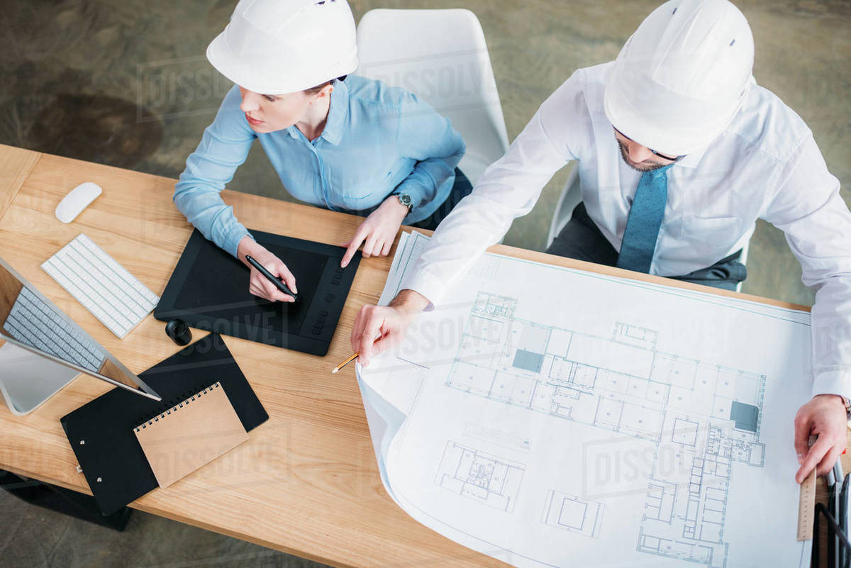 High angle view of architects working with building plan and drawing tablet at office Royalty-free stock photo