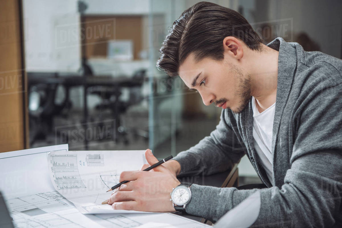 Handsome young architect drawing building plans at office Royalty-free stock photo