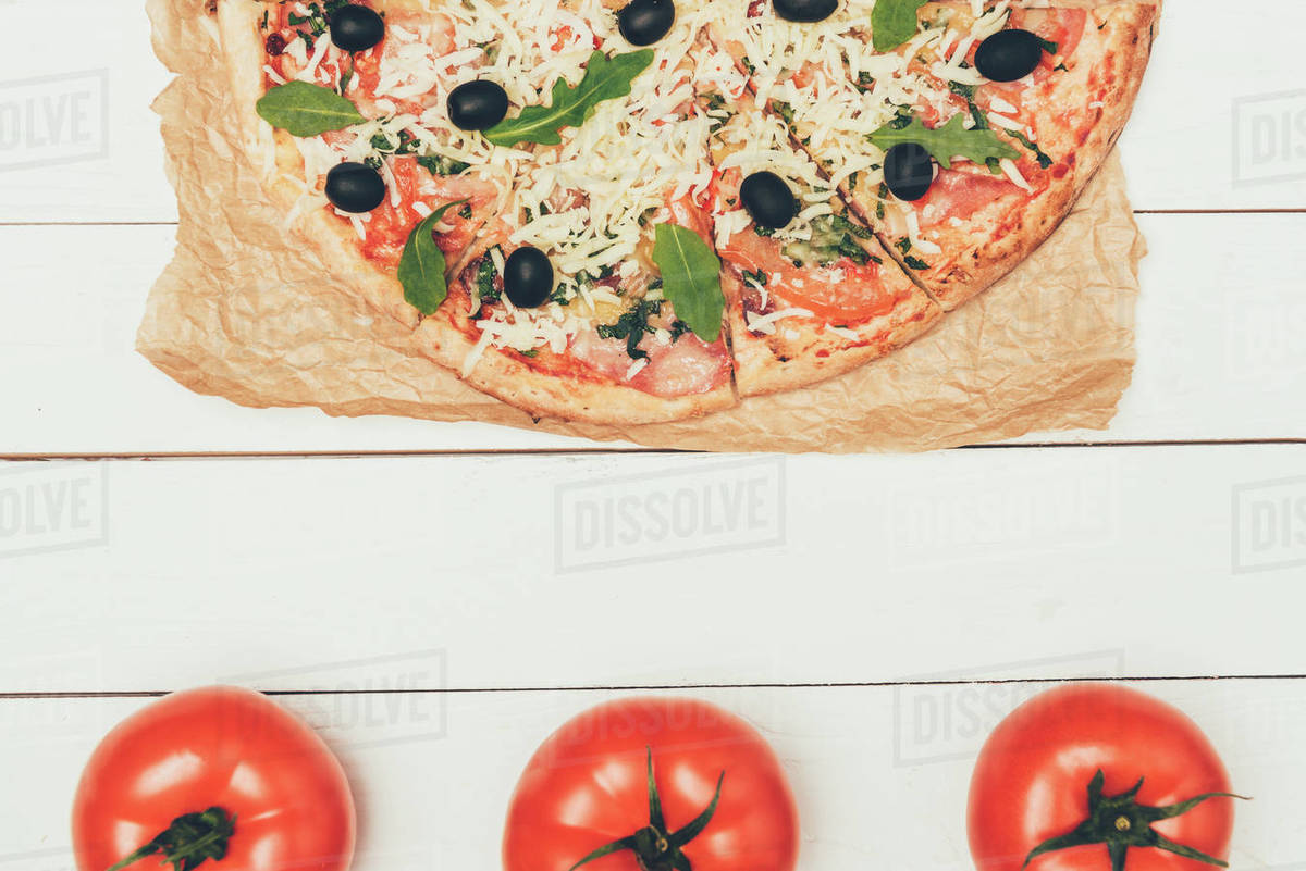 Delicious Italian Pizza And Red Tomatoes On White Wooden Background Stock Photo