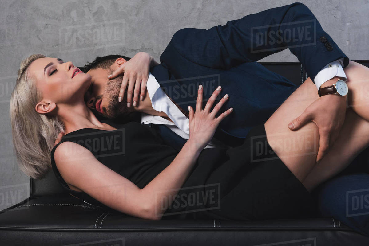 Sexy Young Couple Hugging And Kissing In Foreplay On Couch Stock
