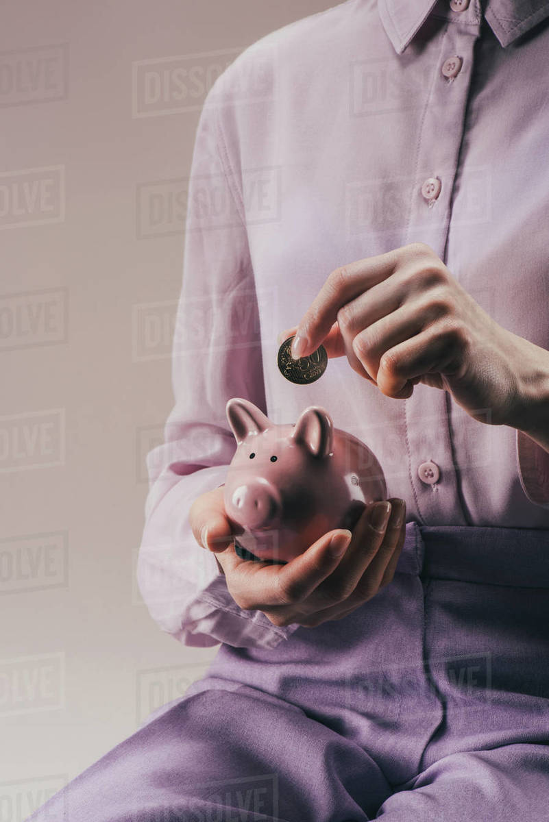 Cropped Shot Of Woman Putting 50 Euro Cent Into Pink Piggy Bank In