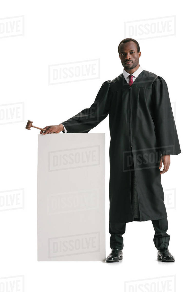 Serious african american judge standing with blank banner judge