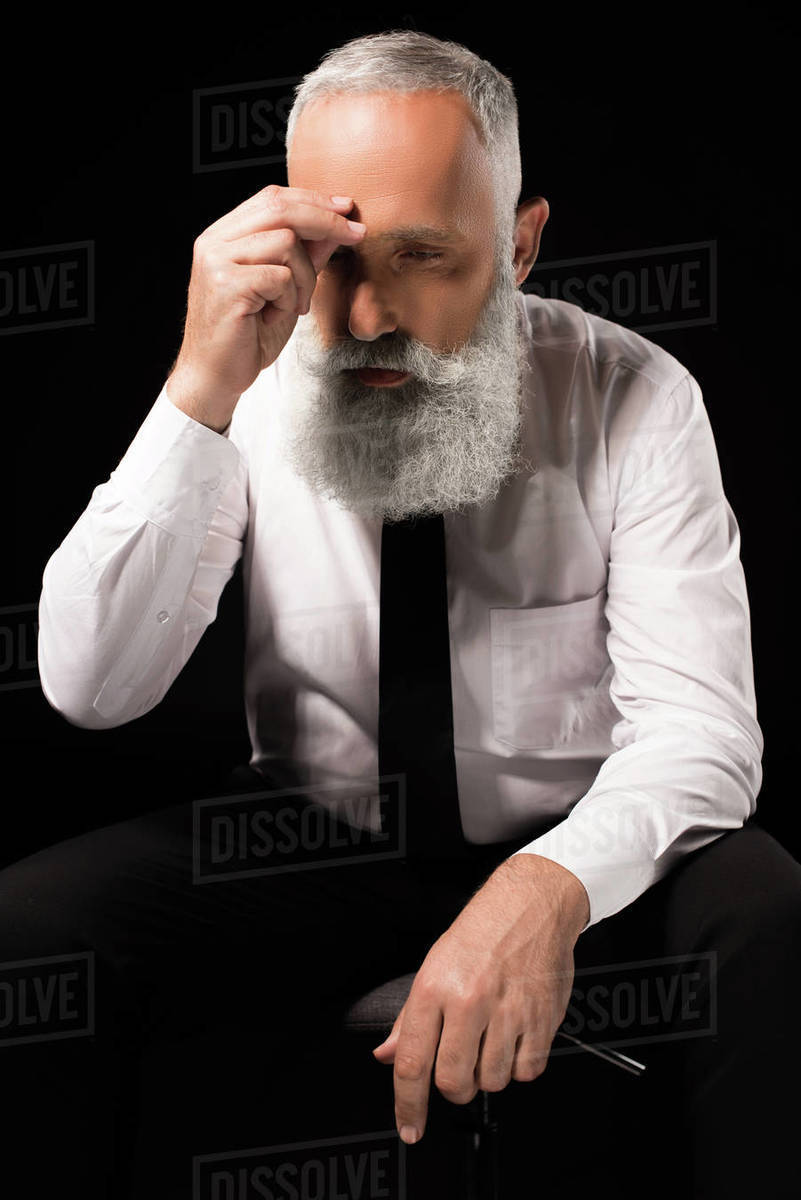 Half Length Shot Of Man In A Suit Sitting On Chair And Rubbing Half Length Shot Of Man In A Suit