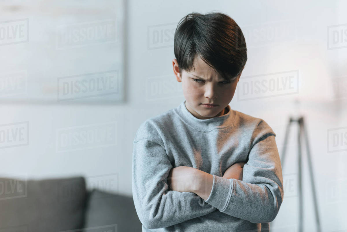 Upset little kid boy with arms crossed at home Stock Photo Dissolve