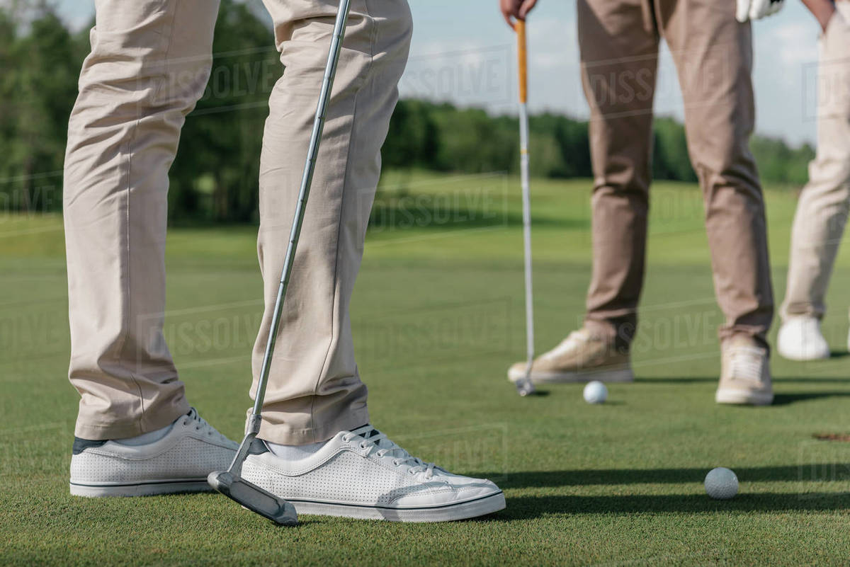 Cropped shot of professional golf players getting ready to shot a ball