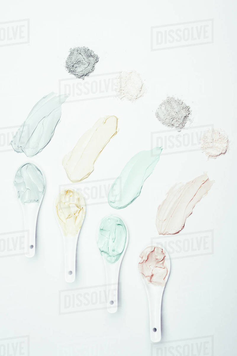 Flat lay with spoons, different clay powder and colorful clay mask