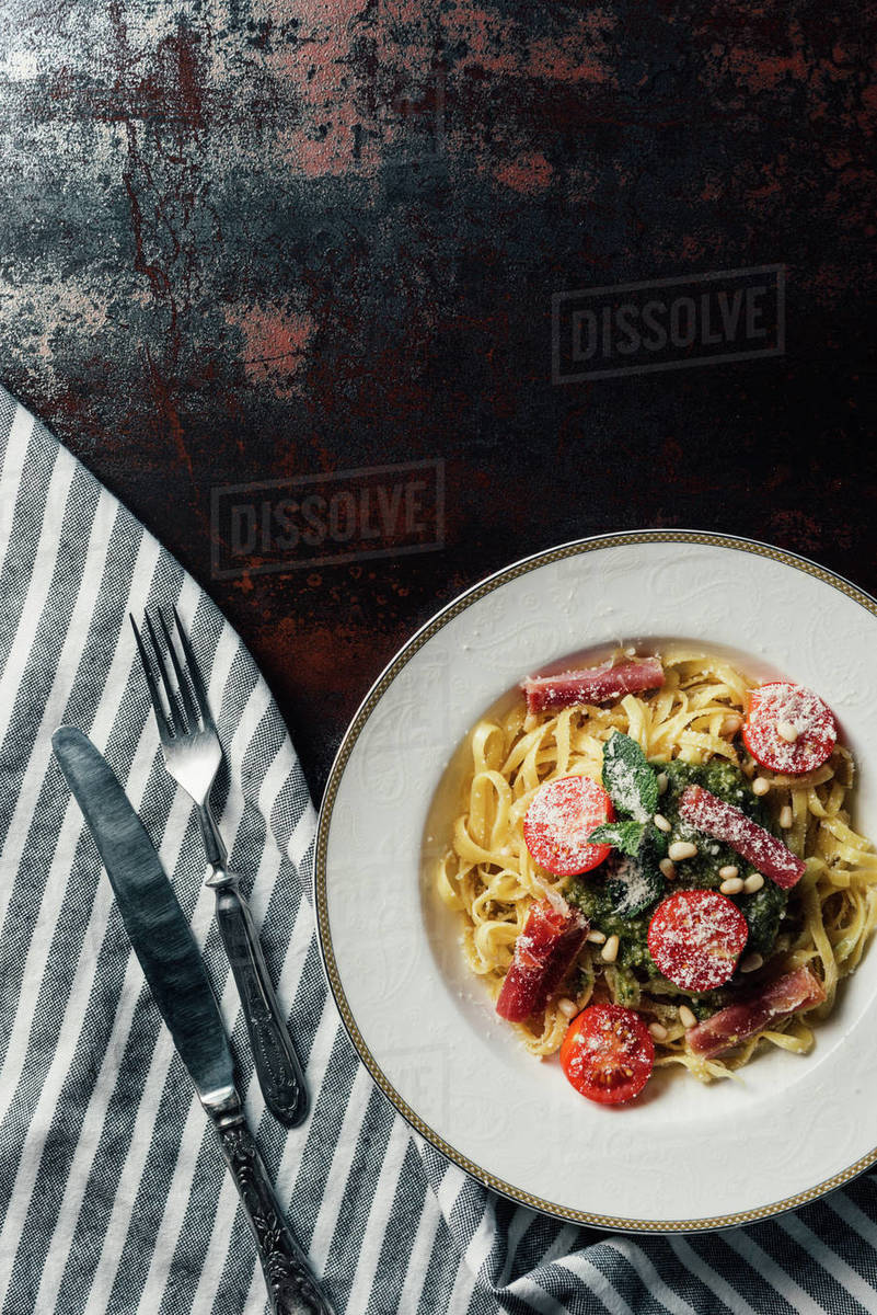 elevated-view-of-pasta-with-mint-leaves-jamon-and-cherry-tomatoes