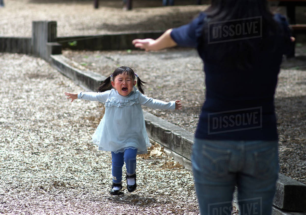 Australia, Melbourne, Crying girl running to mother Stock Photo