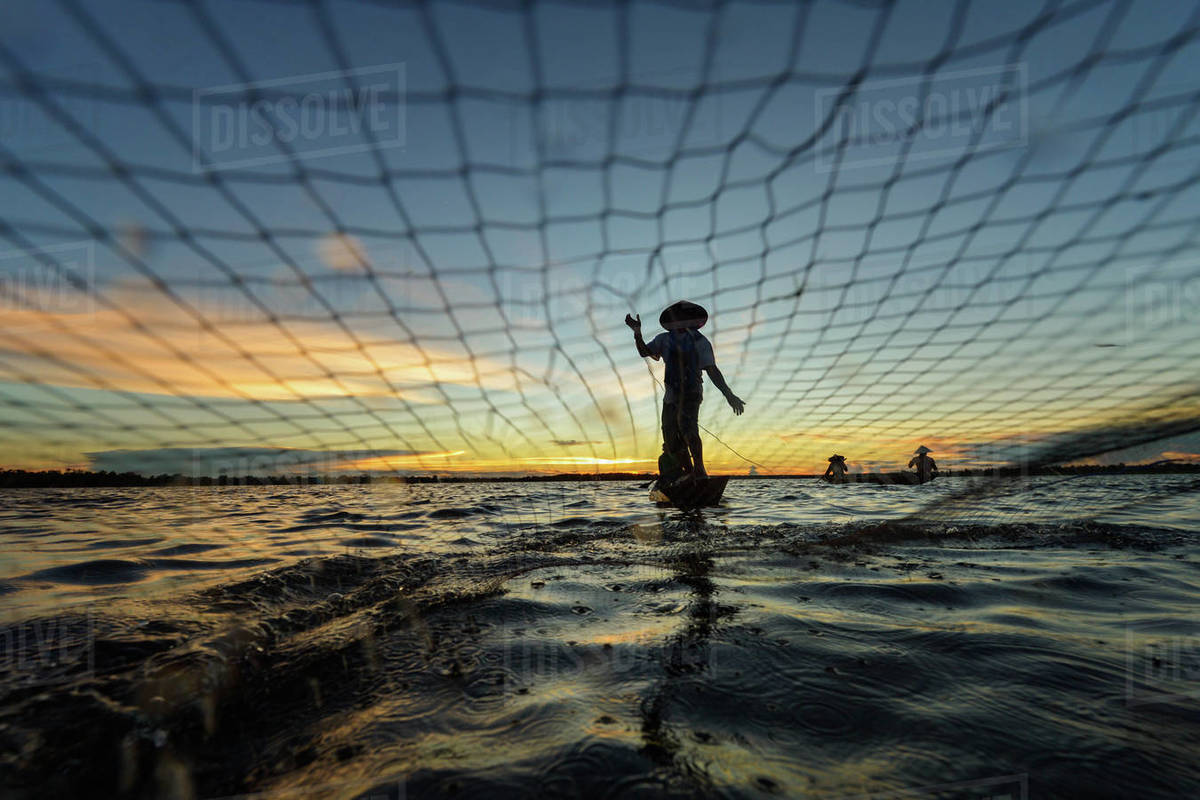 Fisherman casting fishing net at sunset, Nongkhai, Thailand Stock