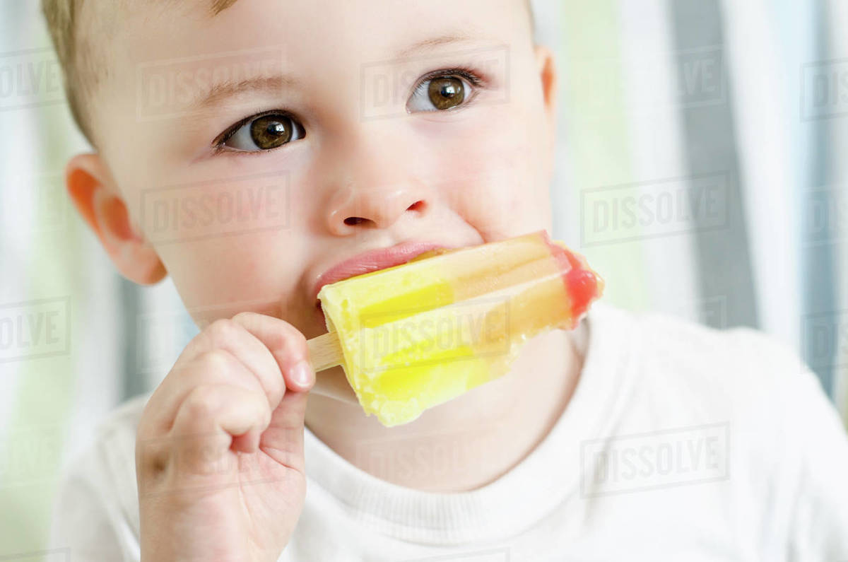 Baby boy eating ice lolly Stock Photo Dissolve