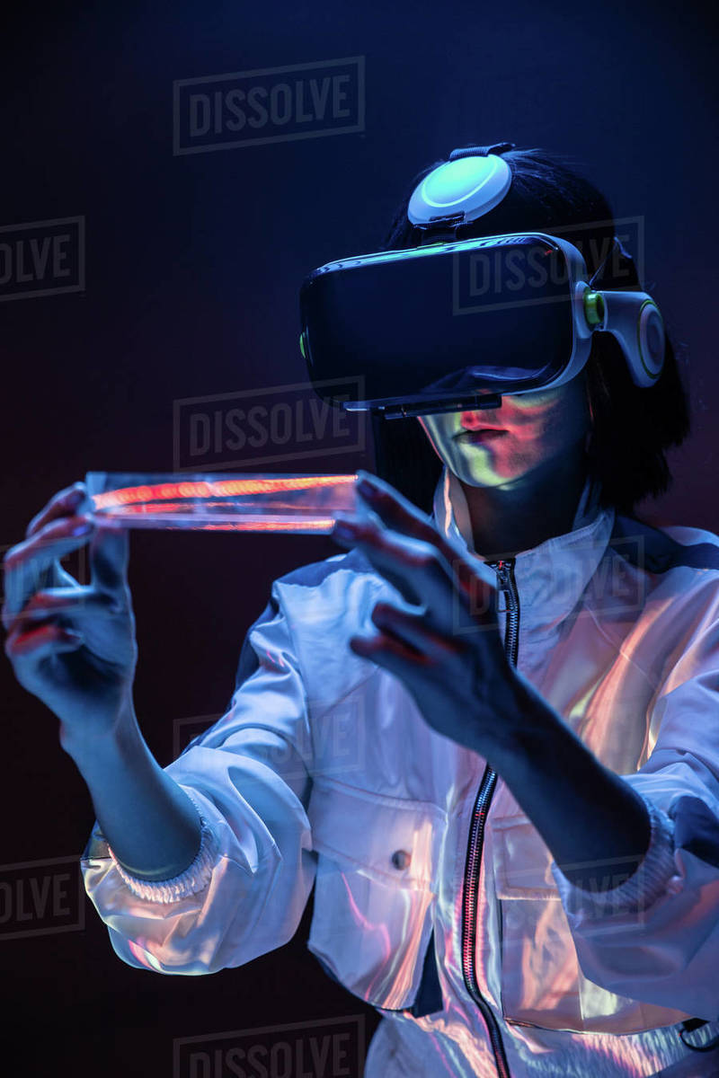 Excited young woman holding a prism while having virtual reality