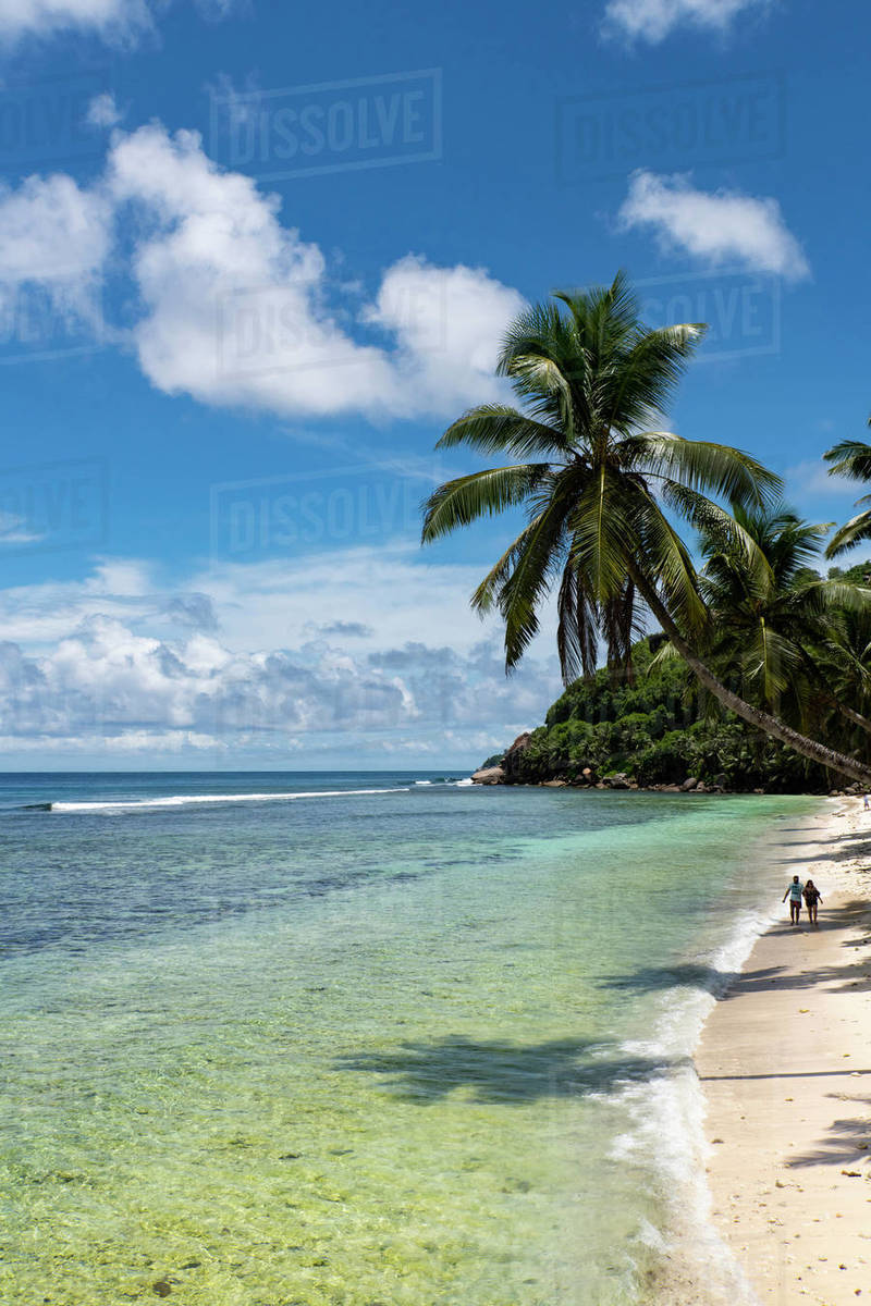 A couple walking along Anse Parnel on the southeast coast of Mahe, Seychelles, Indian Ocean, Africa Royalty-free stock photo