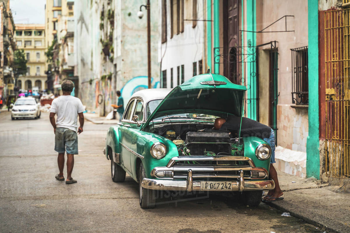 Local fixing his broken down American vintage car, La Habana (Havana), Cuba, West Indies, Caribbean, Central America Royalty-free stock photo