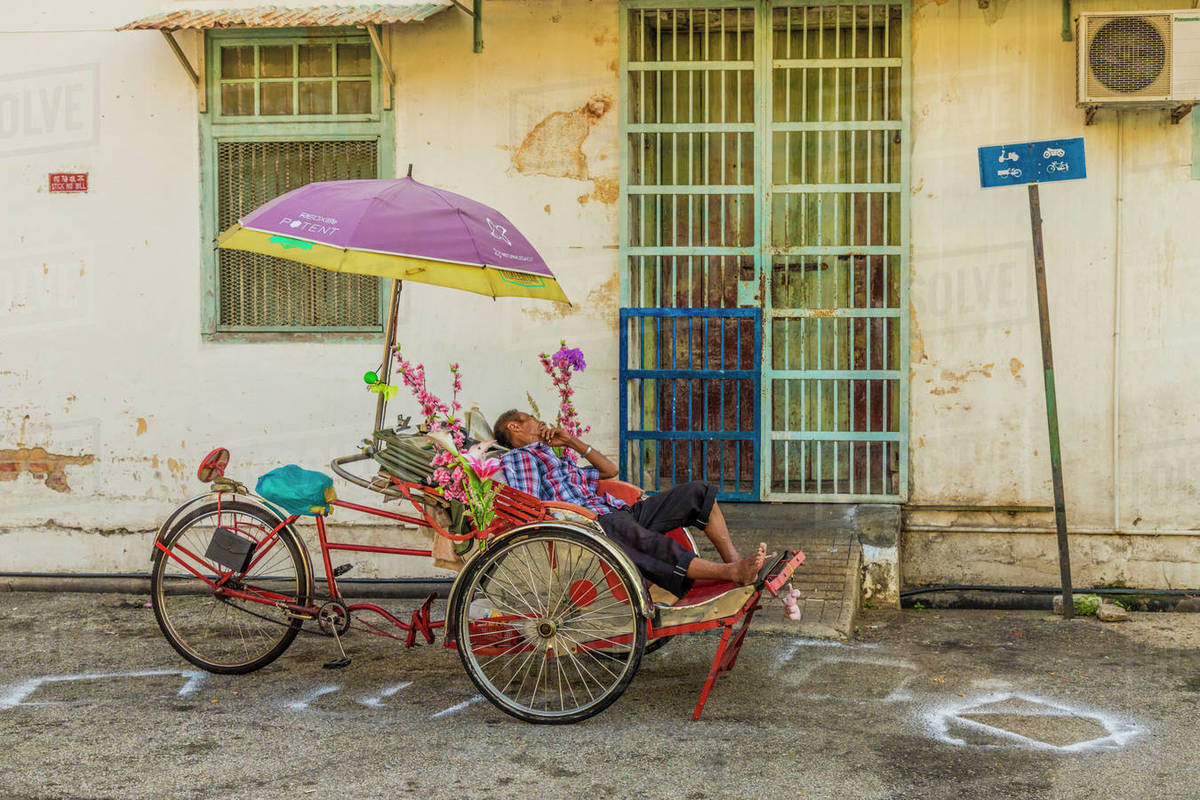 Local rickshaw (tuk tuk) driver in George Town, Penang Island, Malaysia, Southeast Asia, Asia Rights-managed stock photo