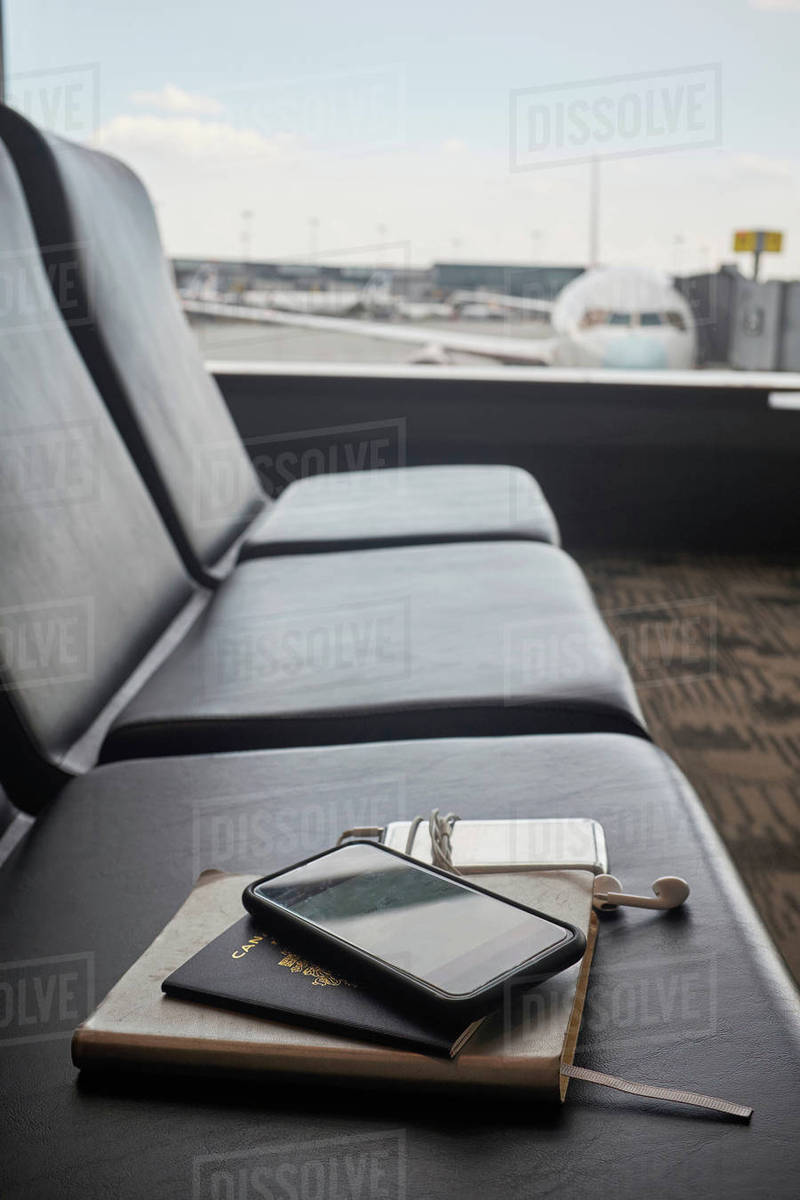 Passport and smartphone on seat in airport lounge Royalty-free stock photo