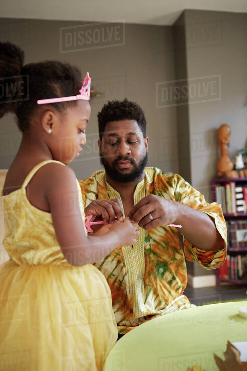 Mature man repairing fairy wand for daughter in kitchen Royalty-free stock photo