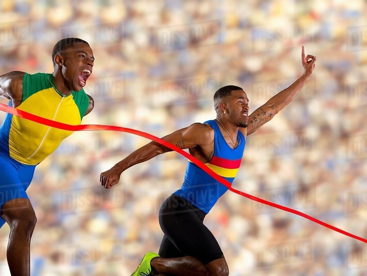 Two athletes reaching finishing line Stock Photo Dissolve