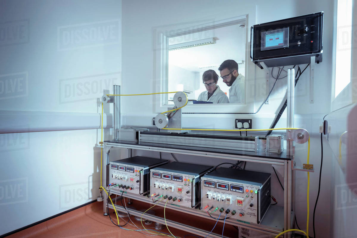 Scientists using cable bending test equipment to test electrical cable