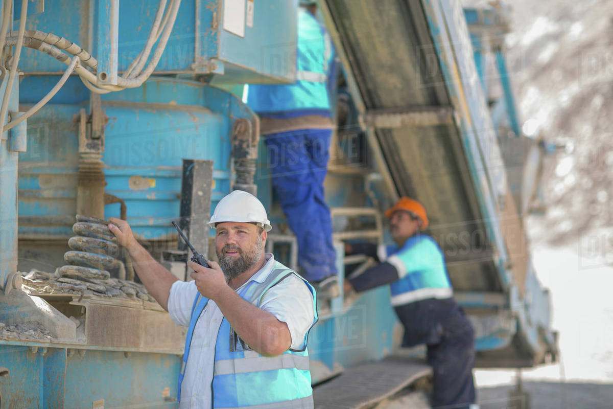 Quarry workers tending to heavy machinery Stock Photo Dissolve