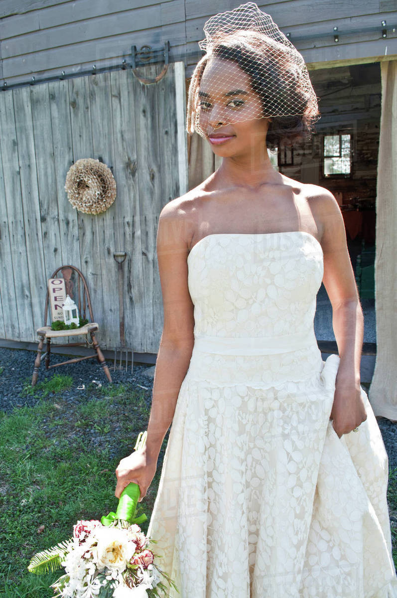 Portrait Of Bride Wearing Wedding Dress And Veil Outdoors Stock Portrait Of Bride Wearing Wedding Dress And Veil Outdoors