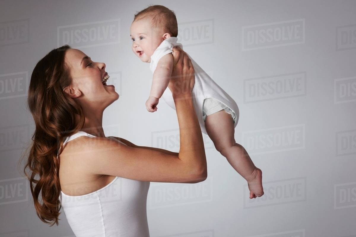 Mother lifting baby daughter Stock Photo Dissolve