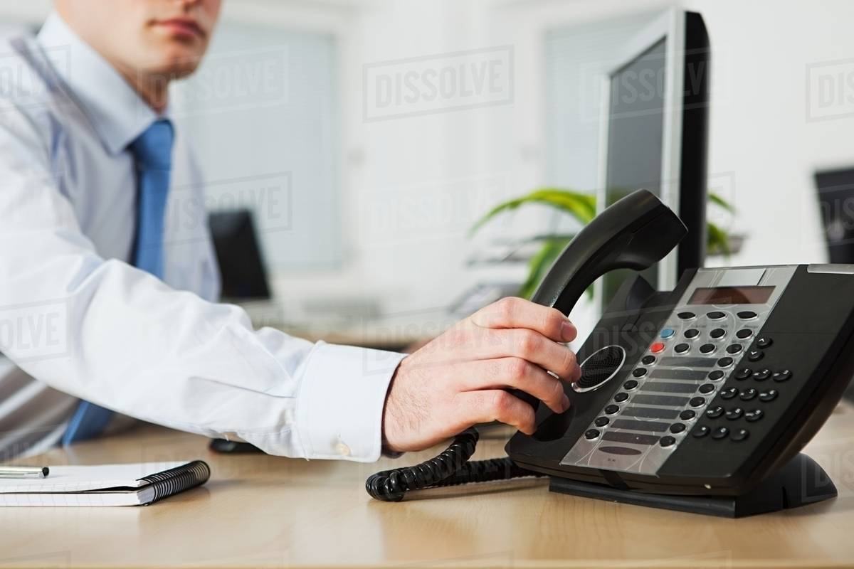 Office worker answering telephone Stock Photo Dissolve