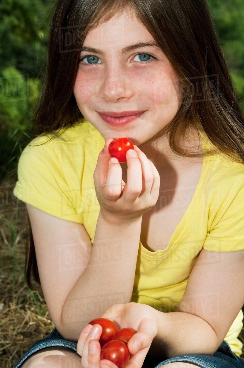 Girl eating cherry tomatoes Stock Photo Dissolve