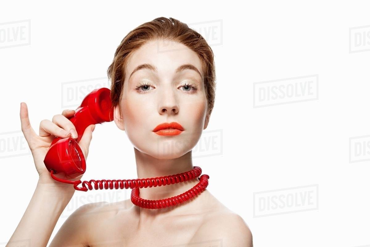 Woman with red telephone cord wrapped around neck Stock Photo Dissolve