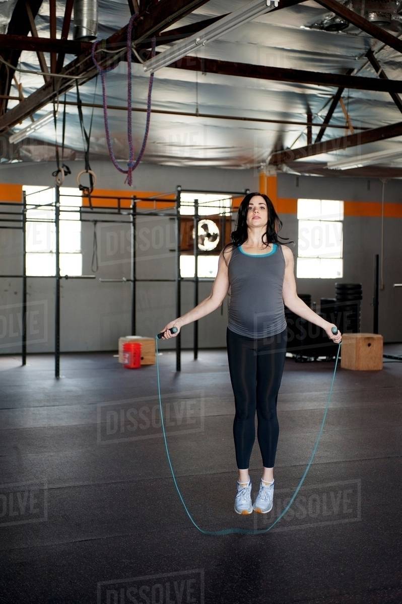 Pregnant young woman skipping with rope Stock Photo Dissolve