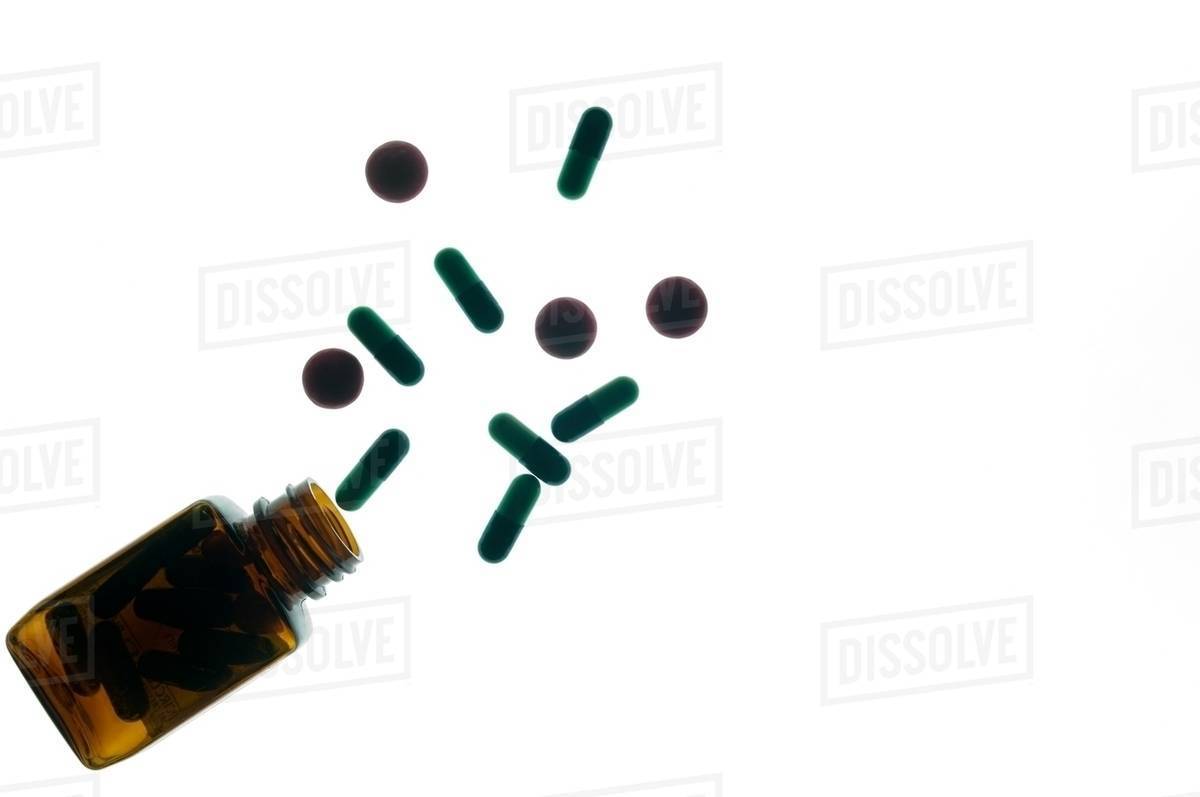 Medicine bottle and capsules Stock Photo Dissolve