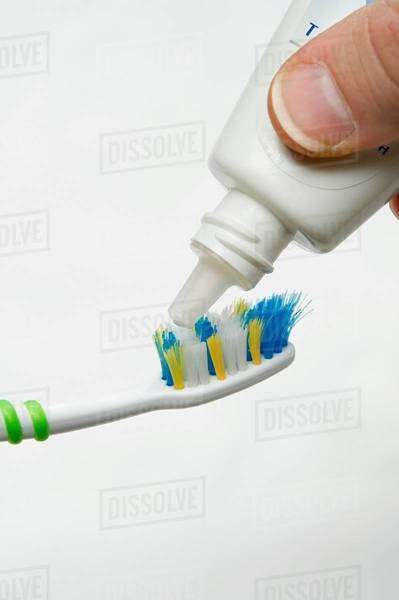 Putting toothpaste on toothbrush - Royalty-free Stock Photo | Dissolve