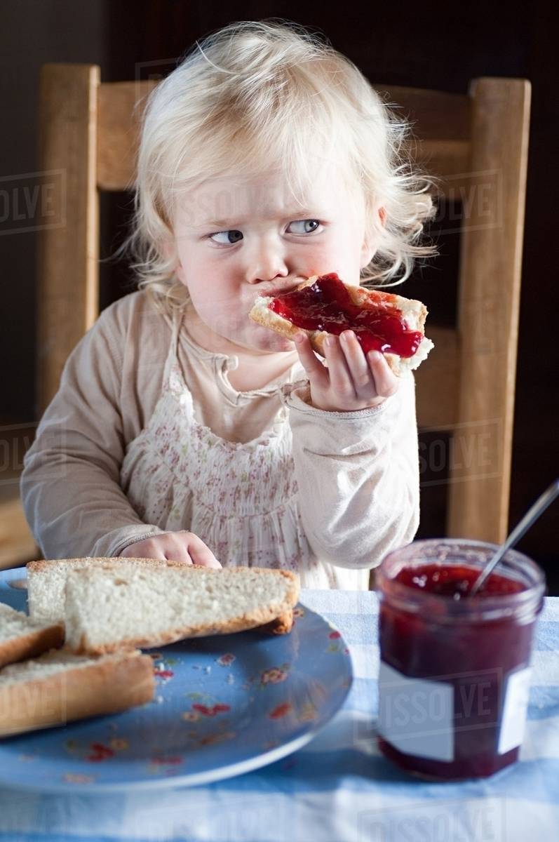 Female toddler eating bread and jam Stock Photo Dissolve