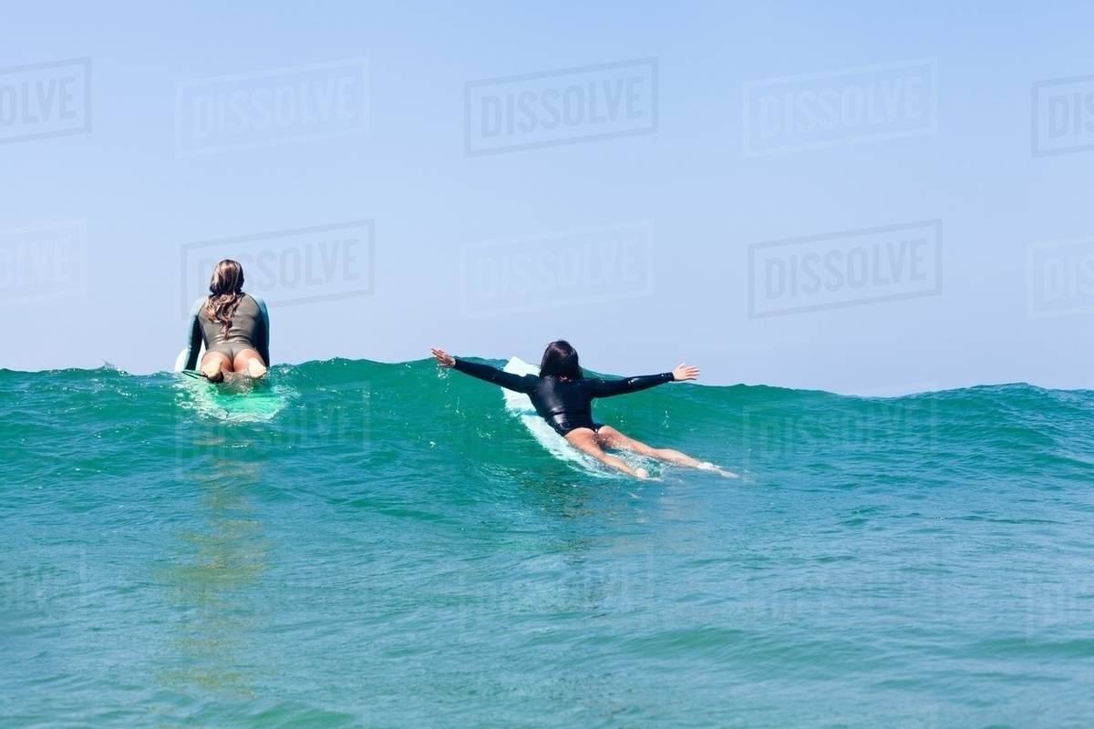 Female friends surfing, Hermosa Beach, California, USA Stock Photo