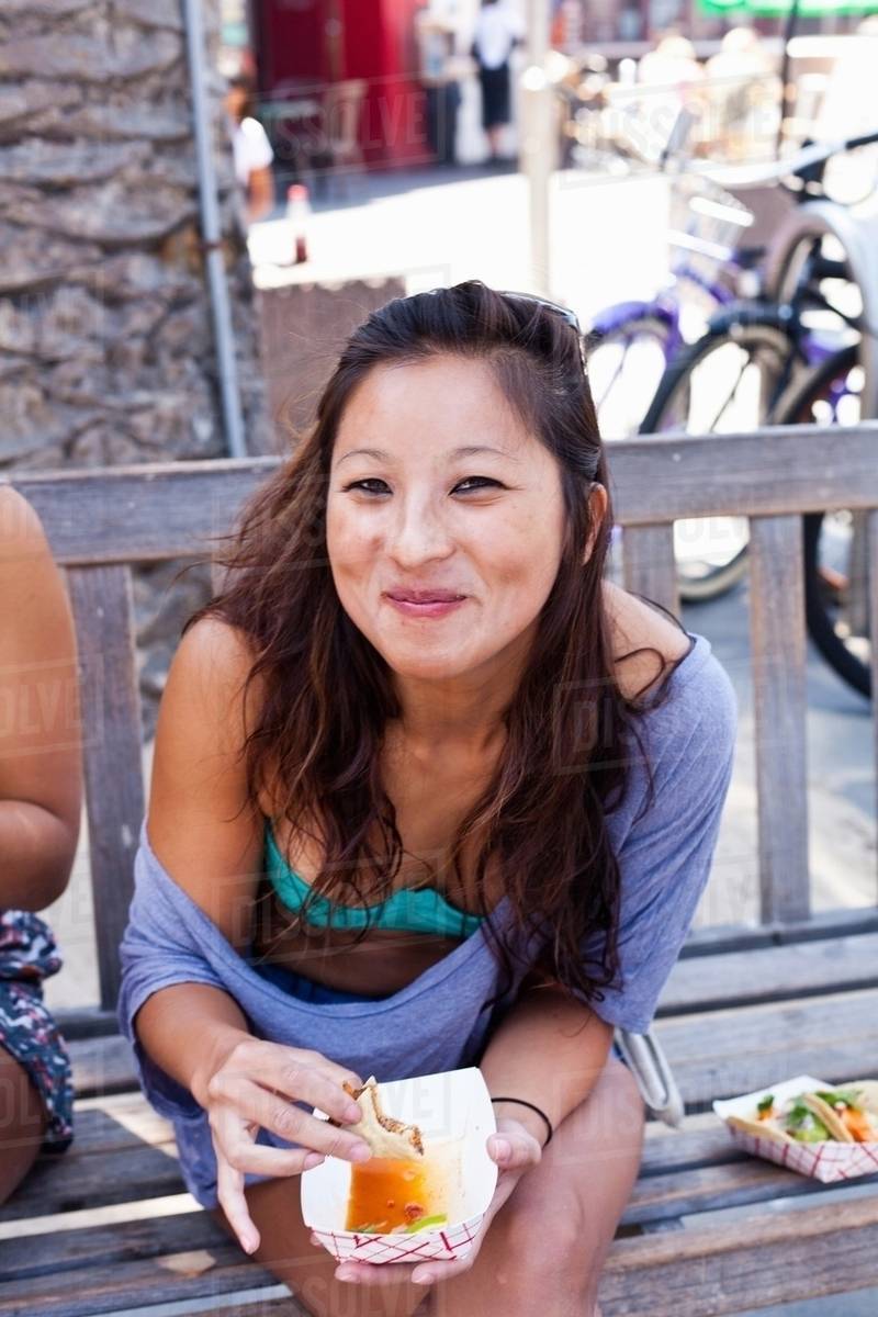 Woman eating takeaway food, Hermosa Beach, California, USA Stock