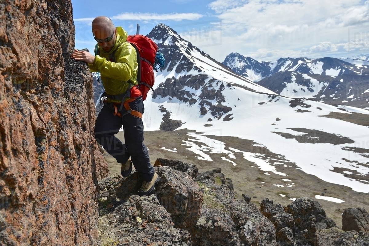 Male mountain climber climbing steep mountain, Chugach State Park ...