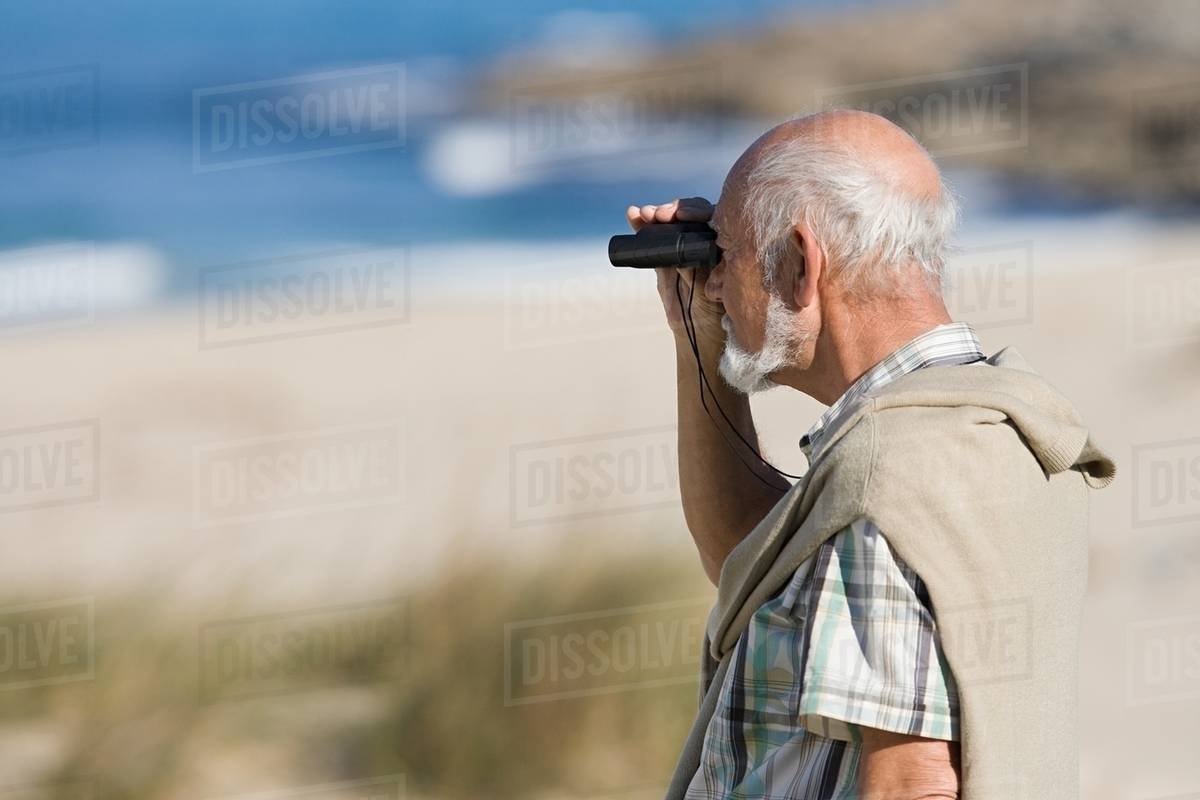 Senior man using binoculars Stock Photo Dissolve