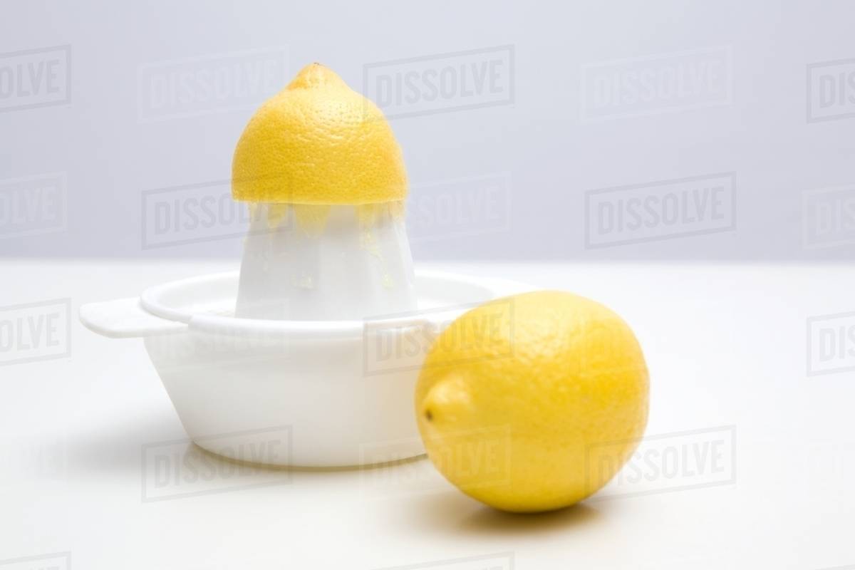 Lemons and a juicer Stock Photo Dissolve