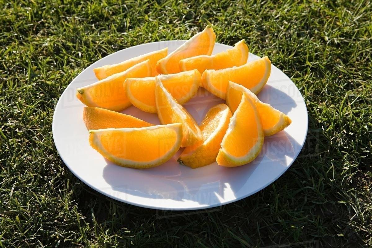 Slices of orange on a plate Stock Photo Dissolve