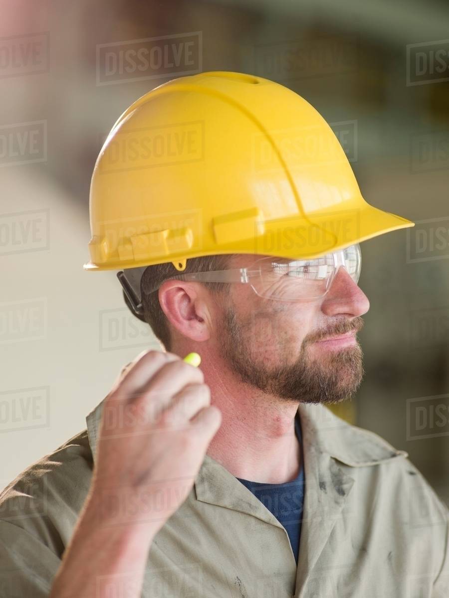 Engineer wearing earplugs on site Stock Photo Dissolve