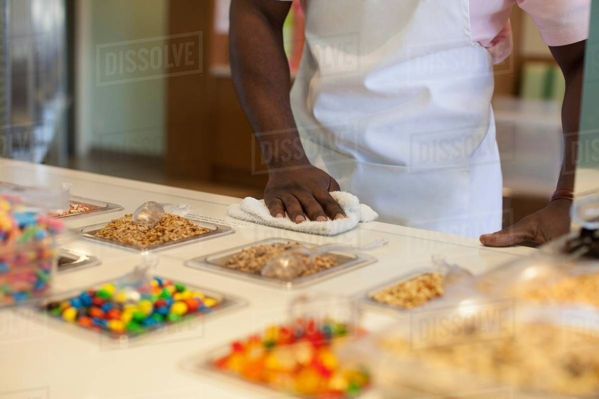 Cashier cleaning counter in store Stock Photo Dissolve
