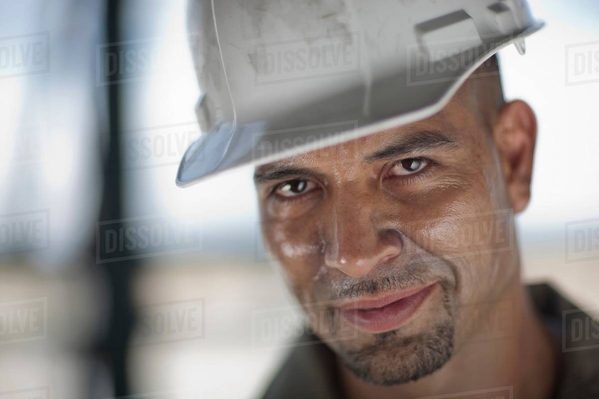 Mid adult construction worker wearing hard hat, looking away Stock