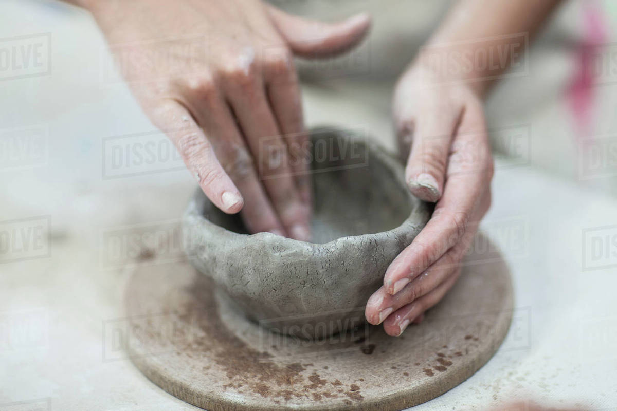 Hands of female potter shaping clay pot in Stock Photo