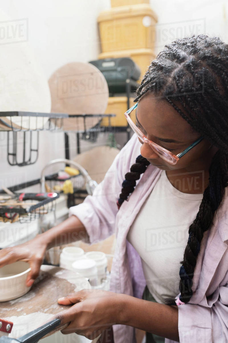 Woman washing her pottery at the ceramics studio Stock Photo Dissolve
